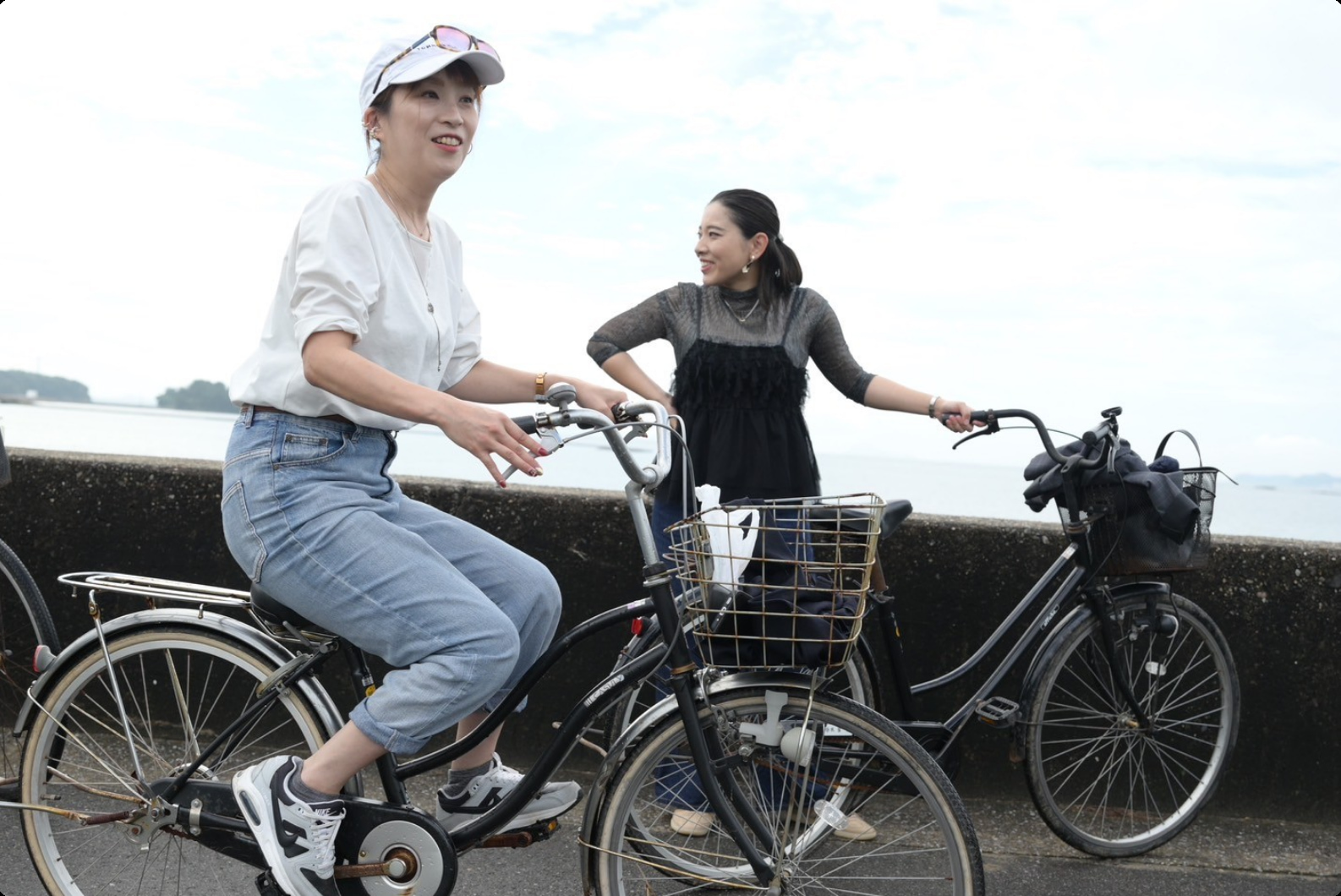 海沿いを自転車で走る保健師の写真